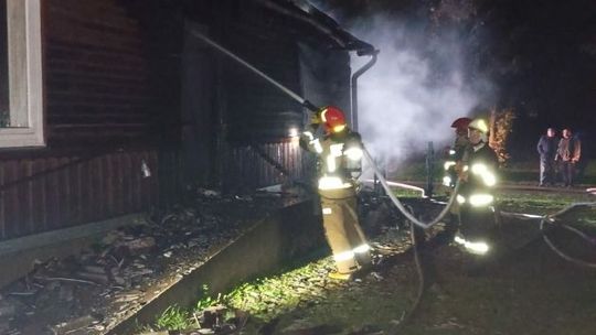 Pożar domu. Na schodach wejściowych kobieta